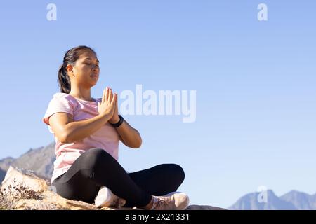 Un'escursionista birazziale che meditava su una montagna, copia spazio Foto Stock