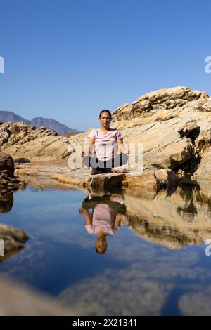 Escursionista birazziale che meditava sull'acqua di montagna, copia spazio Foto Stock