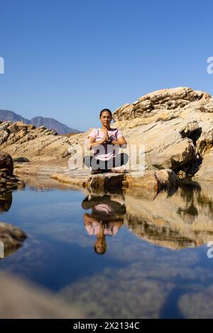 Escursionista birazziale che meditava sull'acqua di montagna, copia spazio Foto Stock