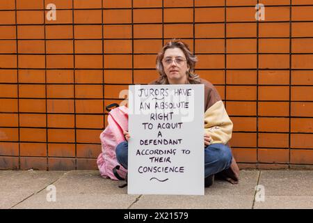 Leeds, Regno Unito. 19 APRILE, 2024. I manifestanti si riuniscono fuori dal tribunale combinato di Leeds come parte della protesta per difendere la nostra Juries dopo essersi riuniti per una fotografia i manifestanti si sono seduti su entrambi i lati dell'ingresso principale del tribunale e non hanno bloccato l'accesso. I manifestanti hanno tutti avuto lo stesso segno di “i giurati hanno il diritto assoluto di assolvere un imputato secondo la loro coscienza” come è stato visto con altre proteste prese in altri tribunali della corona in tutto il paese. Credito Milo Chandler/Alamy Live News Foto Stock