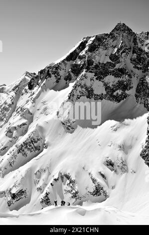 Diverse persone in un tour sciistico si trovano di fronte a Hohem Sonnblick, vom Hocharn, Goldberggruppe, alti Tauri, Salisburgo, Austria Foto Stock