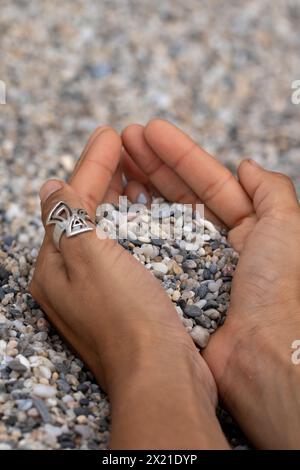 Un ritratto di un ragazzo che tiene la sabbia in una spiaggia Foto Stock