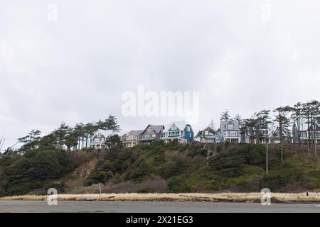 Pittoresche case costiere adagiate su una collina boscosa Foto Stock