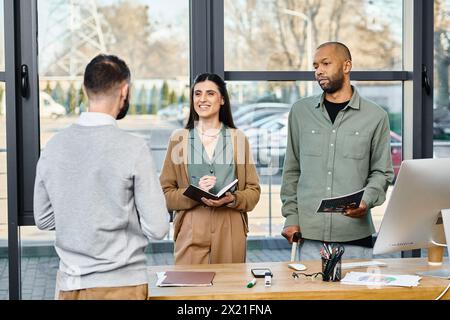Un gruppo diversificato di professionisti si è riunito intorno a una scrivania, impegnato a discutere e a creare brainstorming di idee per un progetto aziendale. Foto Stock