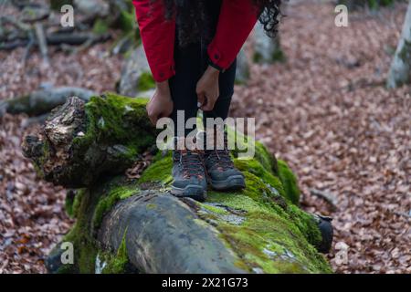 Donna ispanica che cammina attraverso la foresta in autunno Foto Stock