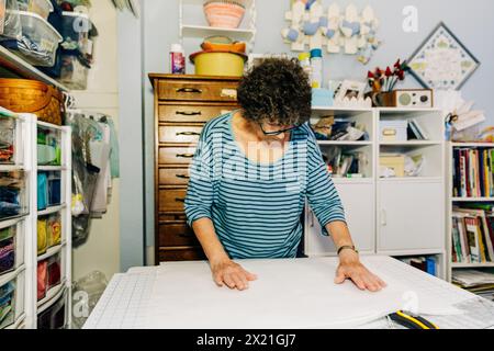 Tessuto di misurazione trapuntato nella sala da cucito Foto Stock