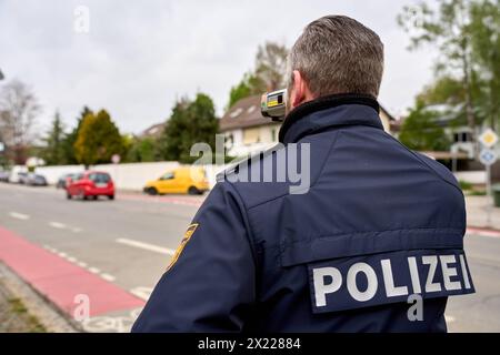 Augusta, Baviera, Germania - 19 aprile 2024: Maratona di autovelox in Baviera. Controllo degli autovelox da parte della polizia di Augusta. Un agente di polizia misura la velocità con un dispositivo di misurazione laser in una zona di 30 km/h *** Themenbild Blitzermarathon a Bayern. Radarkontrolle der Polizei ad Augusta. Ein Polizist misst die Geschwindigkeit mit einem laser Messgerät in einer 30 km/h zona Foto Stock