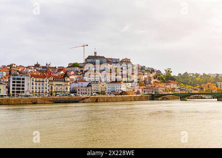 Vista di Coimbra dal fiume Mondego e dall'Università di Coimbra in cima alla collina. Portogallo. Foto Stock