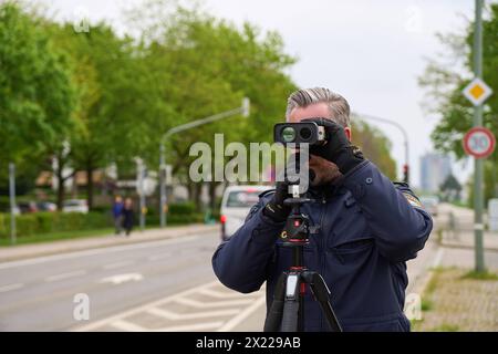 Augusta, Baviera, Germania - 19 aprile 2024: Maratona di autovelox in Baviera. Controllo degli autovelox da parte della polizia di Augusta. Un agente di polizia misura la velocità con un dispositivo di misurazione laser in una zona di 30 km/h *** Themenbild Blitzermarathon a Bayern. Radarkontrolle der Polizei ad Augusta. Ein Polizist misst die Geschwindigkeit mit einem laser Messgerät in einer 30 km/h zona Foto Stock