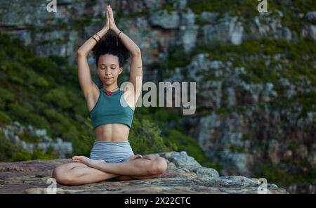 Donna, meditazione e loto in montagna per la consapevolezza la pace o la calma mattutina, la natura o la salute mentale. Donna, mani e chakra bilanciano come Foto Stock