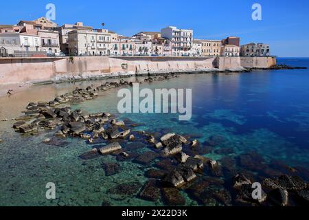 La costa rocciosa orientale dell'isola di Ortigia, Siracusa, Sicilia, Italia, con acque limpide e colorate Foto Stock