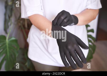 La mano che indossa un guanto di gomma. Simbolo della sicurezza sul lavoro. Trasmette approvazione e comunicazione positiva. Soddisfazione e protezione. Mettendosi a portata di mano Foto Stock