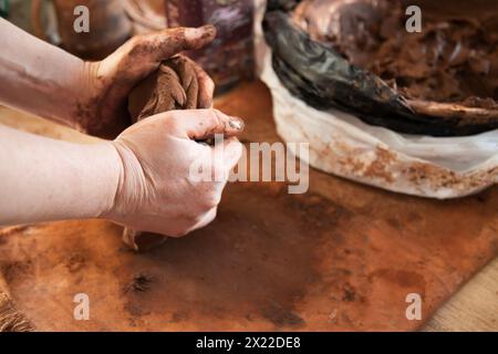 Il processo di realizzazione di un prodotto in ceramica in primo piano. Le mani producono argilla da vari oggetti per la casa e la vendita Foto Stock