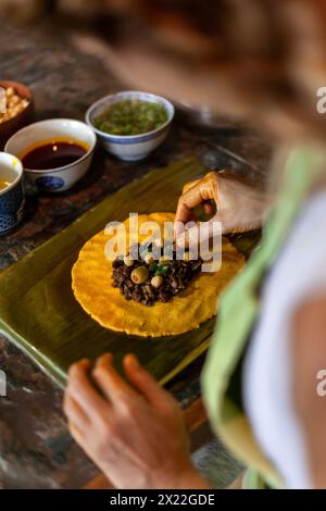 Primo piano di mani che preparano l'hallaca o il tamale. Concetto di cucina tradizionale Foto Stock