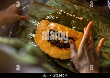 Primo piano di mani che preparano l'hallaca o il tamale. Concetto di cucina tradizionale Foto Stock