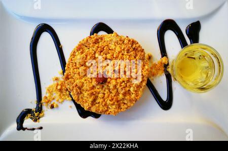 Piatto con torta "sbrisolona" e un piccolo bicchiere di vino bianco Foto Stock