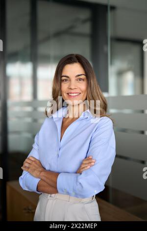 Donna d'affari matura in ufficio che guarda la fotocamera. Verticale verticale. Foto Stock
