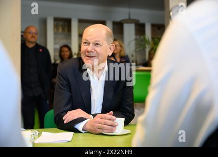 Dresda, Germania. 19 aprile 2024. Il Cancelliere federale Olaf Scholz (SPD) parla con i dipendenti durante la sua visita a una società di costruzioni in legno con sede a Dresda. Insieme al presidente della Confederazione tedesca dell'artigianato qualificato (ZDH) e al presidente della camera di Dresda dell'artigianato qualificato, Scholz partecipa a un tour dei laboratori dell'azienda artigiana specializzata e parla con i dipendenti delle questioni attuali nel settore dell'artigianato specializzato. Crediti: Robert Michael/dpa/Alamy Live News Foto Stock