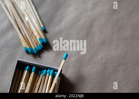 Fiammiferi con testa blu nella loro scatola su sfondo di cartone. Foto Stock