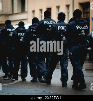 Berlino, Germania. 19 aprile 2024. Gli agenti di polizia di una squadra di cento uomini camminano attraverso la pioggia, scattati durante una manifestazione a Berlino, il 19 aprile 2024. Credito: dpa/Alamy Live News Foto Stock