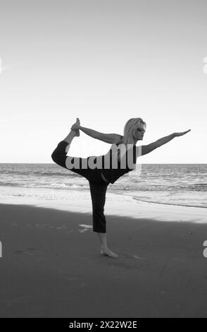 Pretty Young Woman pratica yoga a Hunting Island Beach South Carolina USA Foto Stock