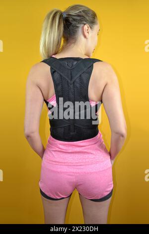 Supporto posteriore e postura su un bellissimo modello che indossa un outfit sportivo rosa Foto Stock