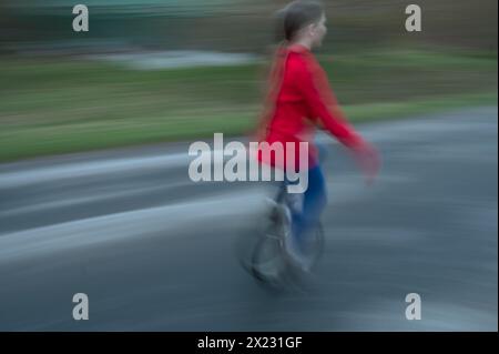 Ragazza, 10 anni, in sella a un unicycle, motion blur, Meclemburgo-Vorpommern, Germania Foto Stock