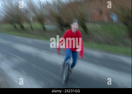 Ragazza, 10 anni, in sella a un unicycle, motion blur, Meclemburgo-Vorpommern, Germania Foto Stock