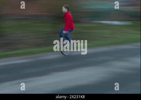 Ragazza, 10 anni, in sella a un unicycle, motion blur, Meclemburgo-Vorpommern, Germania Foto Stock