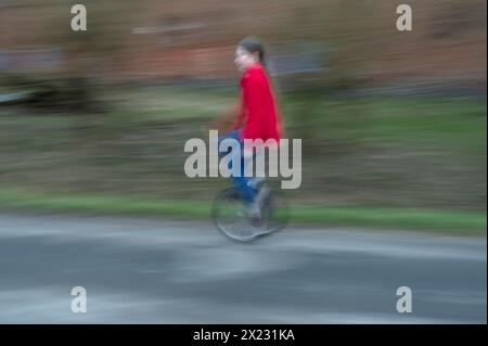 Ragazza, 10 anni, in sella a un unicycle, motion blur, Meclemburgo-Vorpommern, Germania Foto Stock