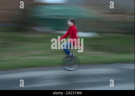 Ragazza, 10 anni, in sella a un unicycle, motion blur, Meclemburgo-Vorpommern, Germania Foto Stock