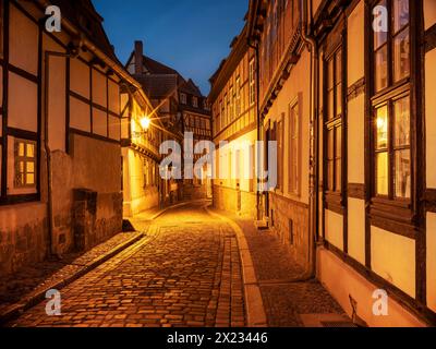 Vicolo stretto con case a graticcio e lastricati nella storica città vecchia al crepuscolo, sito patrimonio dell'umanità dell'UNESCO, Quedlinburg, Sassonia-Anhalt Foto Stock