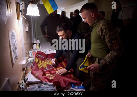 Slovyansk, Ucraina. 19 aprile 2024. Il presidente ucraino Volodymyr Zelenskyy, a sinistra, firma uno striscione militare dalla 95a brigata d'assalto aereo separata durante una visita a un ospedale militare nella regione di Donbas, 19 aprile 2023 a Slovyansk, Oblast di Donetsk, Ucraina. Credito: Handout/Ufficio stampa presidenziale ucraino/Alamy Live News Foto Stock