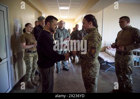 Slovyansk, Ucraina. 19 aprile 2024. Il presidente ucraino Volodymyr Zelenskyy, a destra, assegna una medaglia di stato al membro dello staff medico durante una visita a un ospedale militare nella regione di Donbas, 19 aprile 2023 a Slovyansk, Oblast di Donetsk, Ucraina. Credito: Handout/Ufficio stampa presidenziale ucraino/Alamy Live News Foto Stock