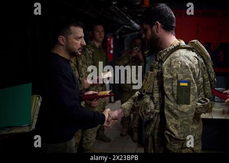 Chasiv Yar, Ucraina. 19 aprile 2024. Il presidente ucraino Volodymyr Zelenskyy, a sinistra, presenta una medaglia militare per l'eroismo a un soldato con la 41a brigata meccanizzata separata in prima linea nella regione del Donbas, 19 aprile 2024 a Chasiv Yar, Oblast di Donetsk, Ucraina. Credito: Handout/Ufficio stampa presidenziale ucraino/Alamy Live News Foto Stock