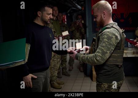 Chasiv Yar, Ucraina. 19 aprile 2024. Il presidente ucraino Volodymyr Zelenskyy, a sinistra, presenta una medaglia militare per l'eroismo a un soldato con la 41a brigata meccanizzata separata in prima linea nella regione del Donbas, 19 aprile 2024 a Chasiv Yar, Oblast di Donetsk, Ucraina. Credito: Handout/Ufficio stampa presidenziale ucraino/Alamy Live News Foto Stock