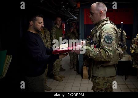 Chasiv Yar, Ucraina. 19 aprile 2024. Il presidente ucraino Volodymyr Zelenskyy, a sinistra, presenta una medaglia militare per l'eroismo a un soldato con la 41a brigata meccanizzata separata in prima linea nella regione del Donbas, 19 aprile 2024 a Chasiv Yar, Oblast di Donetsk, Ucraina. Credito: Handout/Ufficio stampa presidenziale ucraino/Alamy Live News Foto Stock