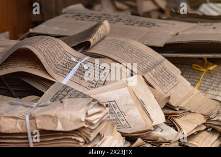 Pila di testi rilegati con scrittura tibetana nel monastero di Kumbum Champa Ling vicino a Xining, Cina Foto Stock