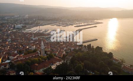 Splendida città vecchia di Izola in Slovenia al tramonto, pittoresco insediamento mediterraneo, ripresa aerea. Concetti di vacanza, viaggio e turismo. Foto Stock