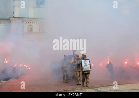 KIEV, UCRAINA - 19 APRILE 2024 - la processione funebre emerge dal monastero di San Michele con la cupola dorata attraverso il fumo di fiamme in seguito al servizio commemorativo per il sergente della 59a Brigata Pavlo Petrychenko che morì mentre difendeva l'Ucraina dalle truppe russe, Kiev, capitale dell'Ucraina. Il militare e attivista ucraino Pavlo Petrychenko era un sergente nella 59a divisione motorizzata di fanteria separata e l'autore della petizione che esortava a limitare i casinò online per il personale militare durante la legge marziale, che ha raccolto i 25.000 voti necessari per essere considerati dal Preside Foto Stock