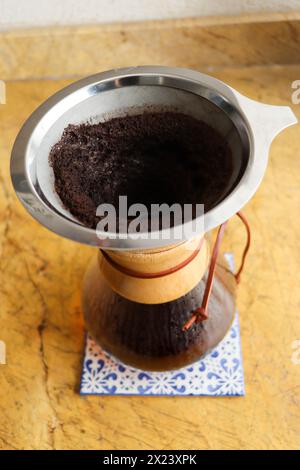 Versare il bicchiere sulla macchina per il caffè su piastrelle in ceramica. Shot verticale, completo, nessuno, versare sulla macchina per il caffè con caffè appena estratto Foto Stock