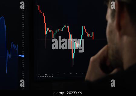 investitore in valuta cripto che analizza i dati del grafico a candelabro digitale sullo schermo del computer. broker azionario che guarda all'indicizzazione della piattaforma di trading di borsa Foto Stock