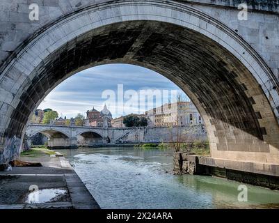 Una vista del fiume Tevere e della città del Vaticano, come si vede sull'argine sotto il ponte Vittoria Emanuele. Foto Stock