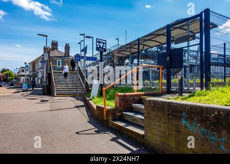 Vista della stazione ferroviaria di Staines-upon-Thames nel Surrey, Regno Unito, con scalini che conducono a un ponte pedonale che attraversa la stazione. Foto Stock