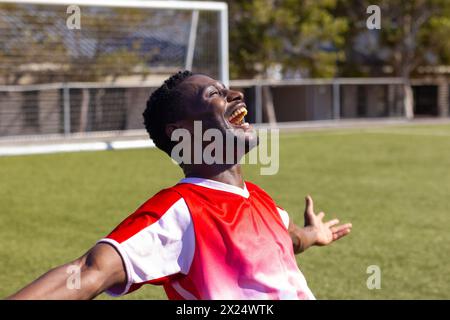 Giovane atleta afroamericano che festeggia all'aperto un campo di calcio, copia spazio Foto Stock