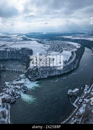 Neuhausen, Svizzera - 22 gennaio. 2023: Immagine Eirale della cascata Rheinfall nel paesaggio invernale innevato con il castello Laufen sulla collina Foto Stock