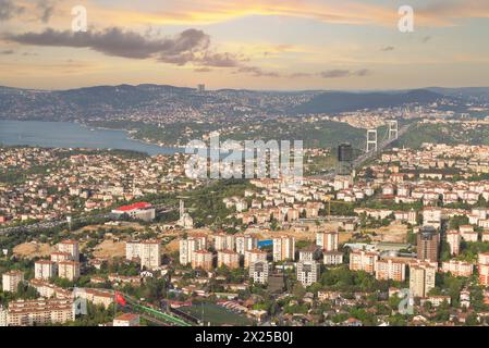 Un tramonto panoramico proietta un caldo bagliore sul paesaggio urbano e sullo stretto del Bosforo, mostrando la bellezza urbana e naturale. Foto scattata dalla torre zaffiro di Istanbul, Turchia Foto Stock