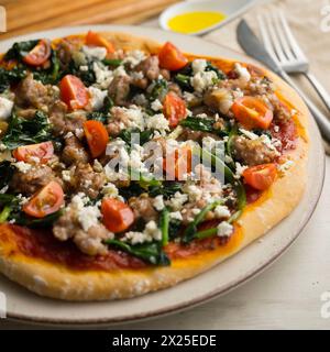 Pizza napoletana con salsiccia e spinaci. Foto Stock