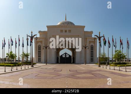 Un'immagine della più lontana porta di Qasr al Watan affiancata da numerose bandiere degli Emirati Arabi Uniti. Foto Stock