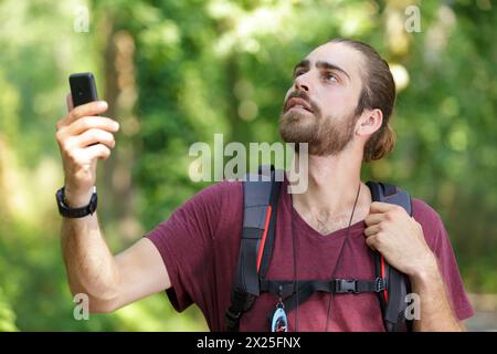 escursionista alla ricerca del segnale di un telefono cellulare Foto Stock